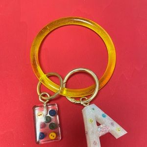Resin wristlets keychain, with a Letter and a charm.
